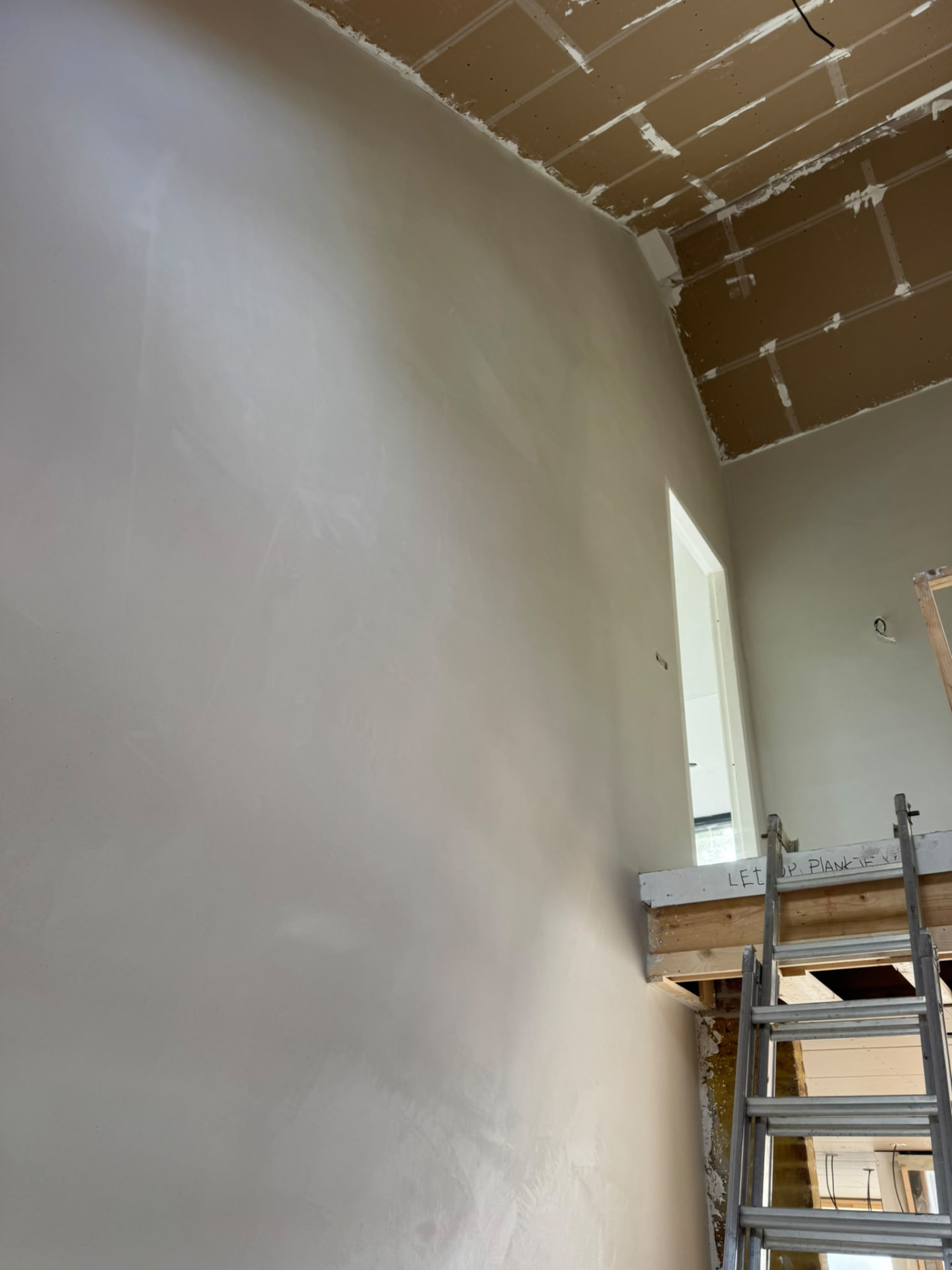 Verse stuc- en pleisterlaag op wand en plafond tijdens de afbouw