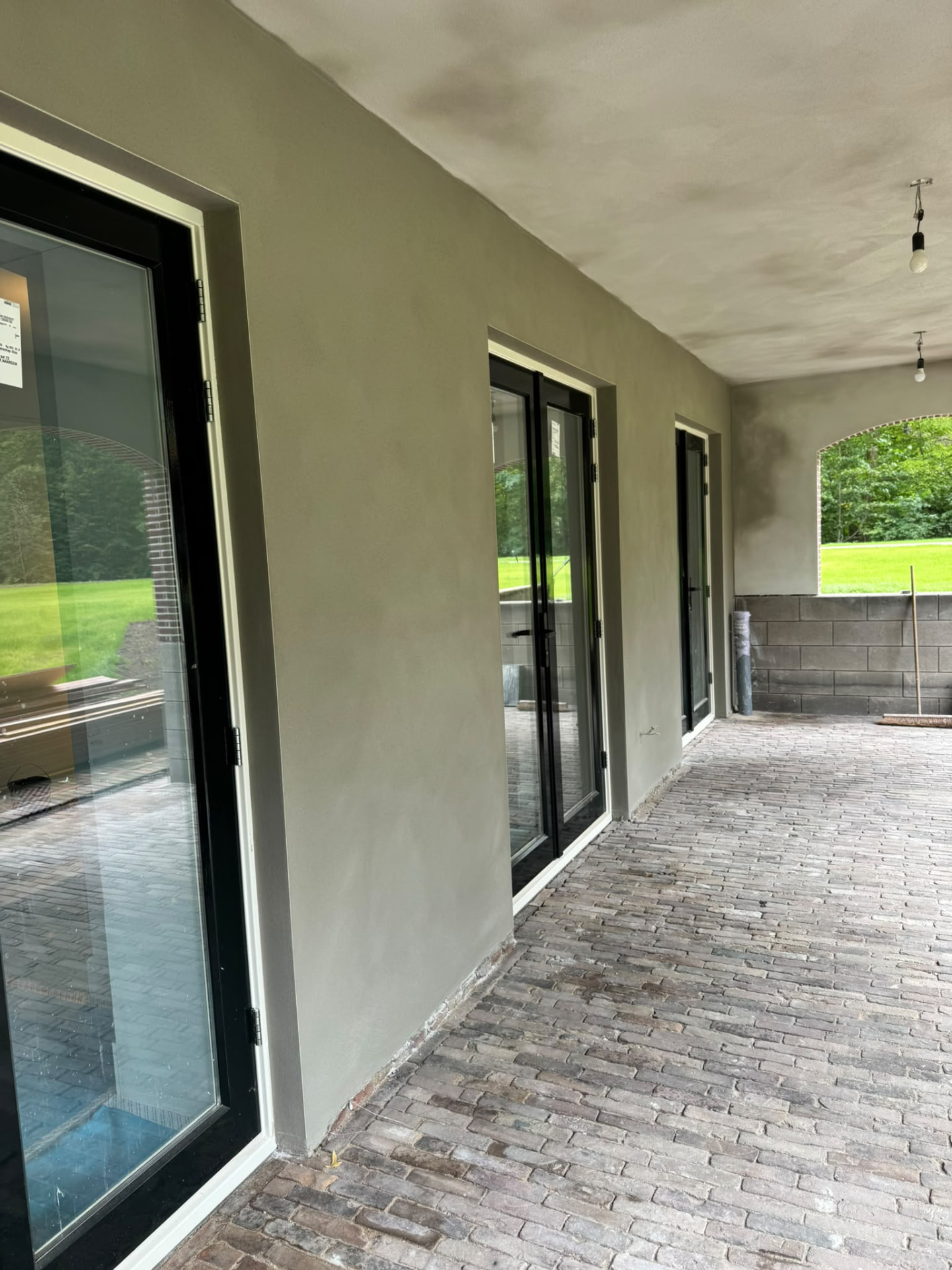 Strak stucwerk aan de buitenmuur van een veranda
